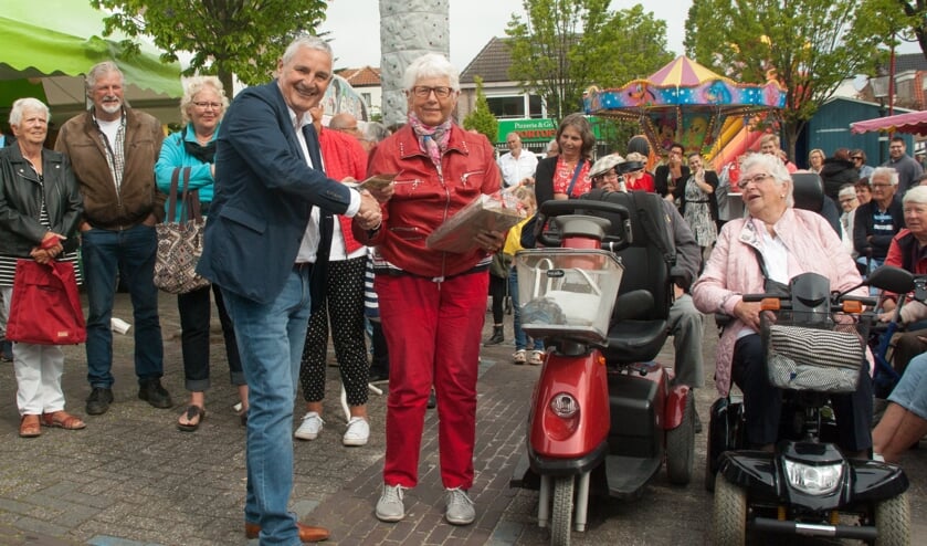 • Wethouder Leon de Wit deelt een prijs van de superloterij uit.