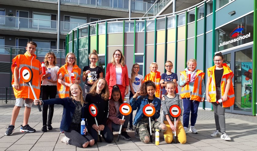 Wethouder Kamstra reikt een bedankje uit aan brigadiers van de Julianaschool.