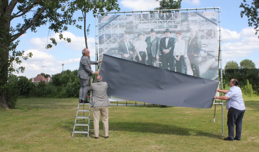 • Jan-Hein de Vreede onthult het laatste doek, geholpen door burgemeester Henny van Kooten en de vader van de fotograaf.