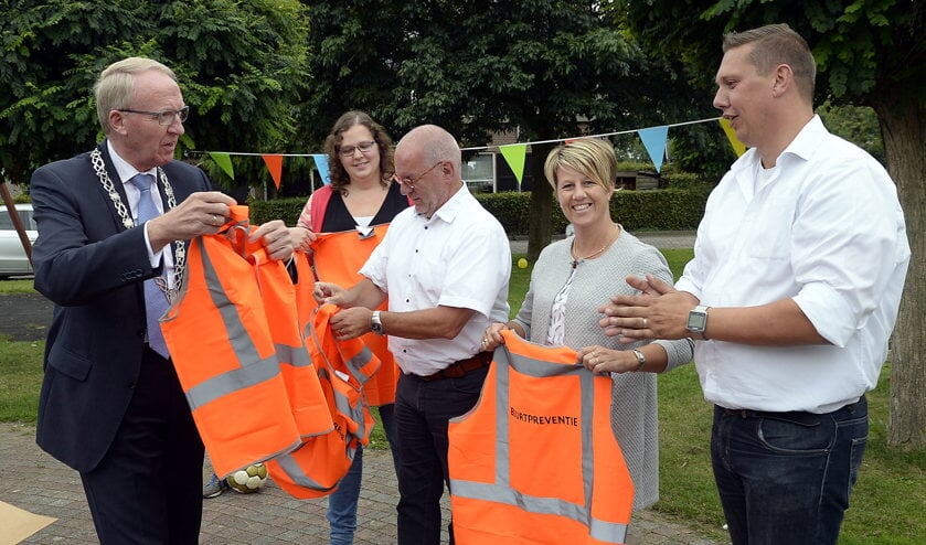 Arie Noordergraaf, de laatste burgemeester van Woudrichem, deelt hesjes uit aan het buurtpreventieteam in Andel, dat in 2017 is opgericht.