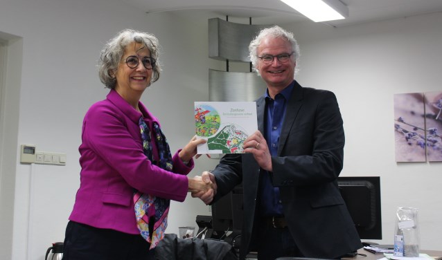 Wethouder John Frenken neemt het boek 'Zonhove – een buitengewoon verhaal' in ontvangst van Jody Cath | Fotonummer: b527bc