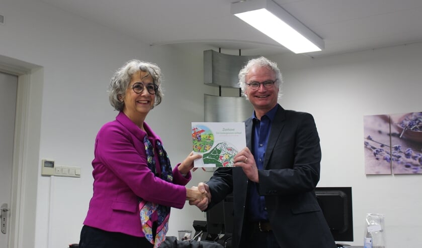Wethouder John Frenken neemt het boek 'Zonhove – een buitengewoon verhaal' in ontvangst van Jody Cath | Fotonummer: b527bc