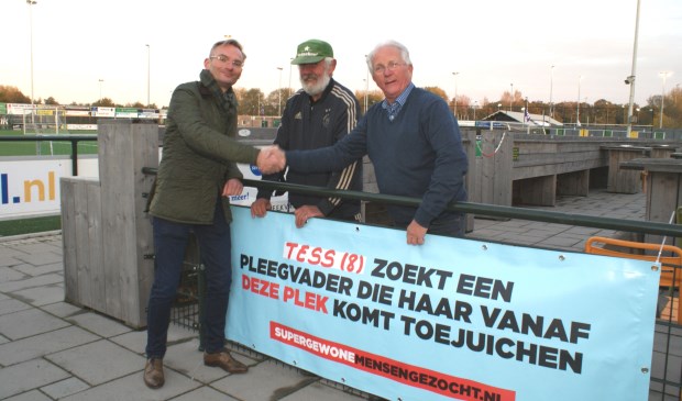Het is de week van de pleegzorg en bij V'97 hangt dit spandoek. Wethouder Mol, Rinus van der Berg en Piet Dubbeling hingen het woensdag op. Foto: VSK