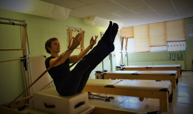 Sylvia Temmink demonstreert een pilates oefening op de Peak Pilates trainingsbank. Foto: Vsk