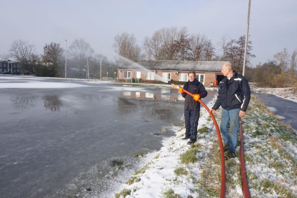 Met man en macht wordt gewerkt aan het ijs van de natuurijsbaan. Foto's: VSK