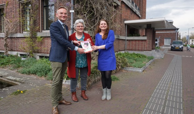 Coördinator VoorleesExpress Fariidah van Leeuwen (Stichting JES Rijnland) biedt Wethouder Nanning Mol een eerste exemplaar van het onderzoek 'Werkt de VoorleesExpress?' aan. Foto: VSK