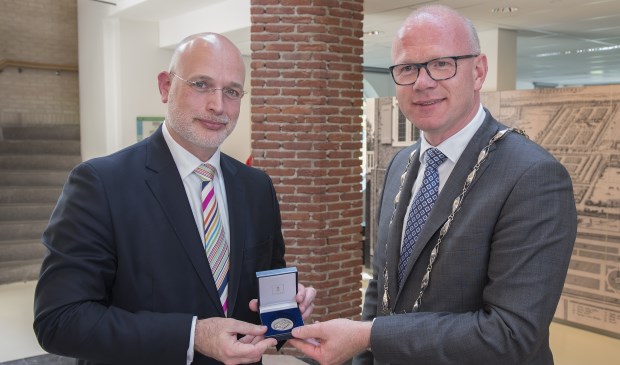 Wethouder Frank Rozenberg ontvangt uit handen van burgemeester Frank Tigelaar de Vroedschapspenning voor scheidende wethouders en raadsleden (foto: Michel Groen).