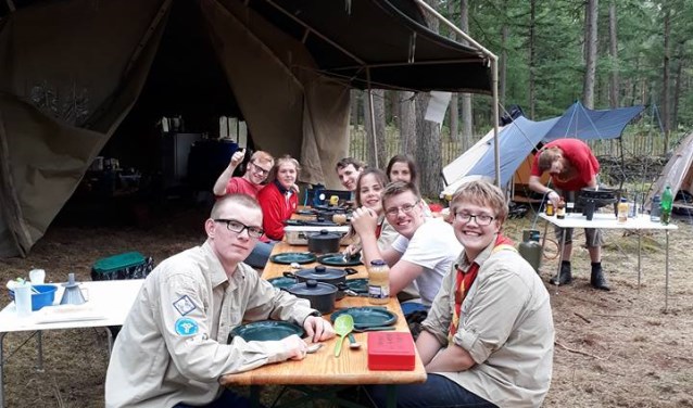 De vrijbuiters van Scouting JMC zitten klaar voor de maaltijd nadat ze zelf gekookt hebben. Foto: pr