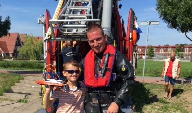 Daan met zijn bootje en de duiker van de brandweer die het vaartuigje voor hem bevrijdde.