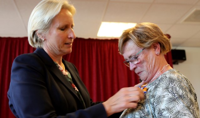Mendy van Veen speldt de koninklijke onderscheiding op bij Jacqueline van den Akker. (foto's Astrid Abbing)