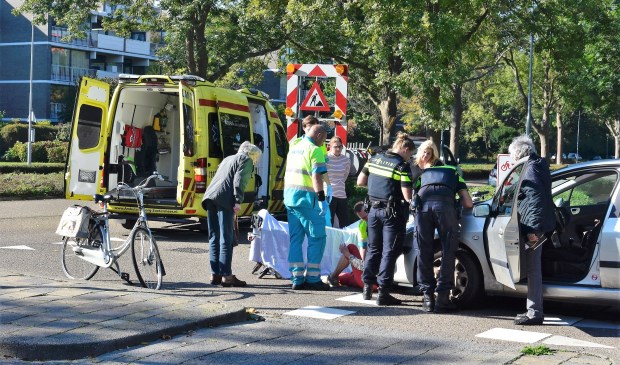 De gewonde vrouw wordt verzorgd door ambulancepersoneel (foto: Lucien de Vries).