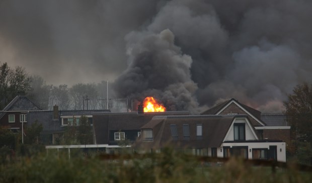 Een vuurzee en grote vlammen te zien achter de bebouwing in Stompwijk (foto: Roy Wolters/Regio15).