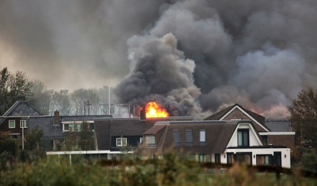 Een vuurzee en grote vlammen te zien achter de bebouwing in Stompwijk (foto: Roy Wolters/Regio15).