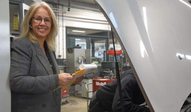 Tessy brengt de werkorder naar de garage waar de collega's van Carteam Harteveld aan de slag gaan, in december met nog meer plezier. Want dan is de sfeer nog leuker.