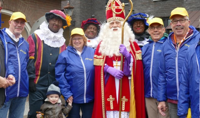De Gastvrije Geuzen zijn herkenbaar aan gele petten en blauwe jacks. Hier zijn ze te zien met de Sint en enkele Pieten. Foto: Jan van Es
