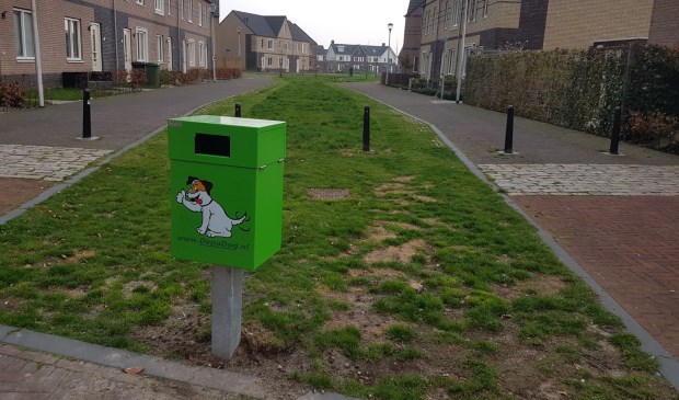 Een lelijke groene strontbak siert de straat.
