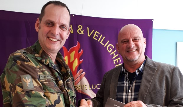 Het eerste exemplaar van het boek van Willem Dekker (r.) werd in ontvangst genomen door de waarnemend commandant DIVI, majoor Van Meegdenburg. Foto: pr