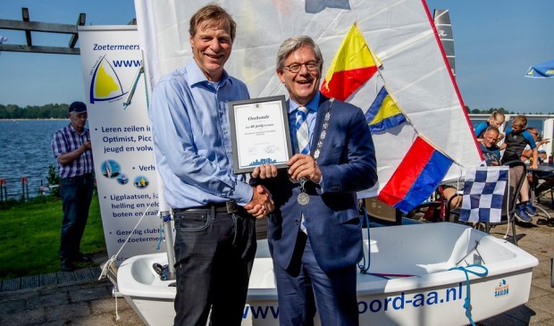 Burgemeester Aptroot reikt de oorkonde uit in verband met het 40-jarig bestaan van de watersportvereniging. Foto: Patricia Munster