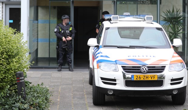 Twee ingangen van de flat werden bewaakt door zwaarbewapende politiemensen. (Foto: Regio15)