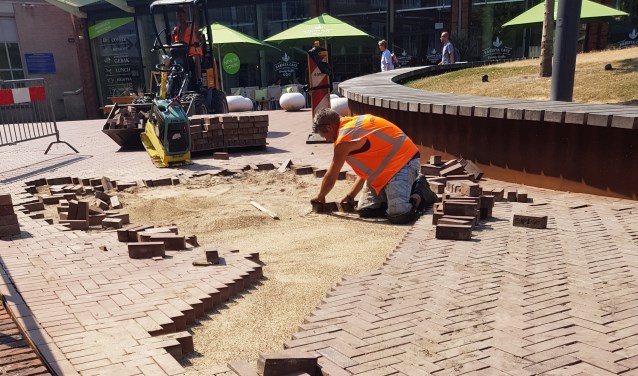 Stratenmakers leggen in de bloedhitte stenen op Cadenzaplein. Foto: S. Bout