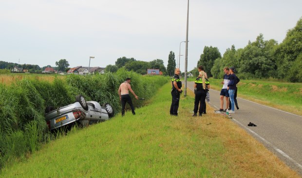 De auto raakte door onbekende oorzaak in de sloot naast de weg (foto: Olav Spa).