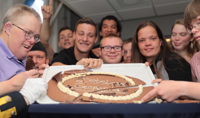 De cliënten konden niet wachten om een groot chocolade ei kapot te mogen slaan, waarin uiteindelijk een chocoladebord met de tekst 'Zoetelaar Geopend' zichtbaar werd. Foto: Jan van Es