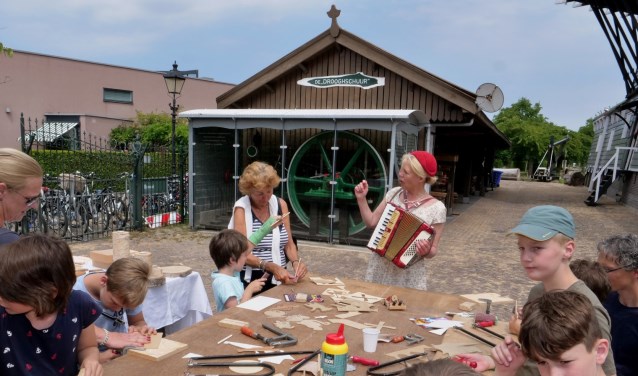 Angelique Schipper zingt liedjes bij De Salamander, terwijl kinderen figuurzagen (foto: Ot Douwes).