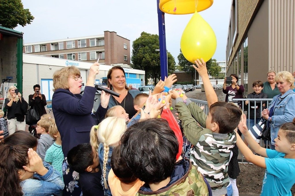 De wethouders prikken een ballon met knikkers door, die door de kinderen mochten worden opgeraapt (foto's: Ap de Heus).