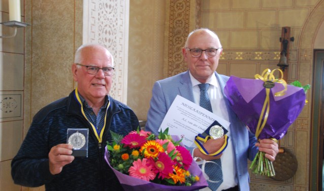 Theo van der Hoeven (l.) en Fons van der Linden (r.) ontvingen de Nicolaaspenning voor vele jaren vrijwilligerswerk in de H.Nicolaasparochie. Foto: pr