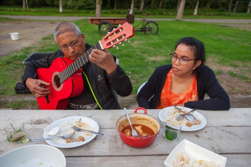 Vrijlligers aan het werk in de tuin en daarna samen eten.