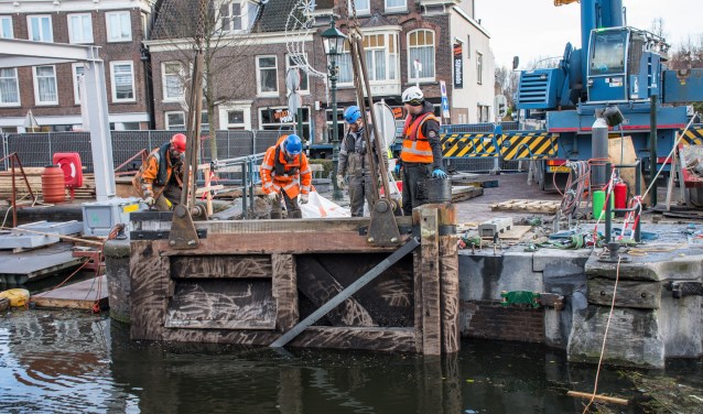De eerste sluisdeur wordt teruggehangen in de Leidschendamse sluis (foto: AS Media).