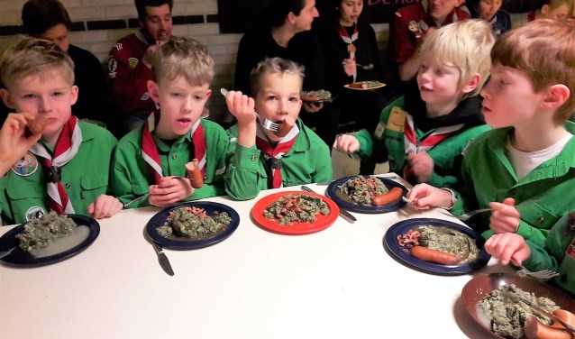 De scouts, van jong tot oud, en de leiding genoten van de boerenkool tijdens de nieuwjaarsopkomst (foto: Muriel de Vreede).