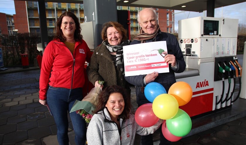 Marga en Rob Koster mogen een jaar gratis tanken bij AVIA. Ze kregen een cheque en bloemen van Cindy en Ruby van AVIA Pijnacker.