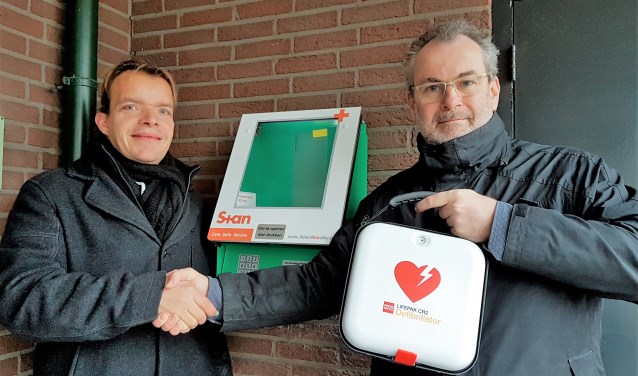 Wouter Verbeek van RLT Nederland (l.) en Adrey Caljé van het bestuur van VvE De Populier met de AED (foto: pr).