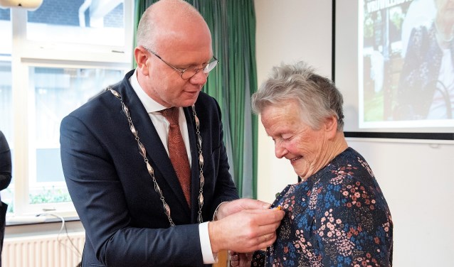 Burgemeester Klaas Tigelaar speldde Mw. Went-Rurup de versierselen op, behorende bij haar benoeming tot Lid in de Orde van Oranje-Nassau (foto: Michel Groen).