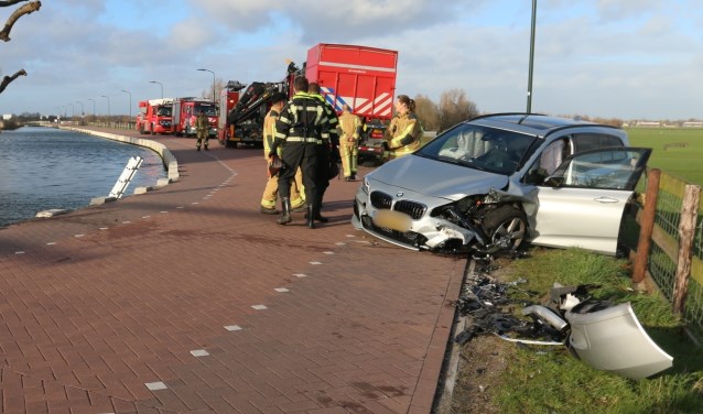 De schade aan zowel het voertuig op de kant als de auto in het water is groot (foto: Ruben van Essen).