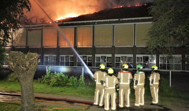 Het vuur sloeg al snel door het dak van de Maerten van de Veldeschool, waarna het te gevaarlijk werd om het pand te betreden en de school als verloren werd beschouwd (foto: Regio15).