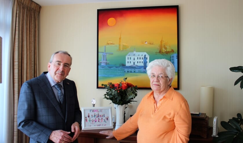 John de Prieëlle met zijn vrouw Thera bij het schilderij van Ries Kleijnen. Dit kreeg hij bij zijn afscheid als burgemeester van Pijnacker. Op het dressoir staat een familietekening gemaakt door een van de kleinkinderen.