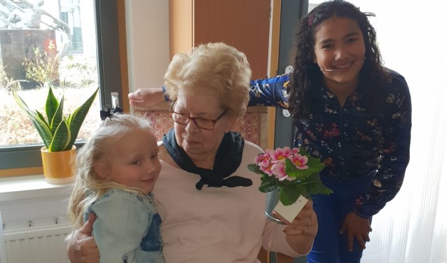 Jade (6 jaar) en Nasira (11 jaar) brengen voorjaarsplantjes naar ouderen in woonzorgcentrum Vivaldi Zoetermeer. Foto: pr