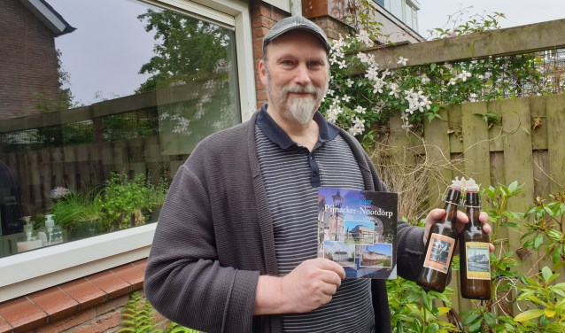 Erik met bier en boeken in de groene achtertuin van zijn vriendin.