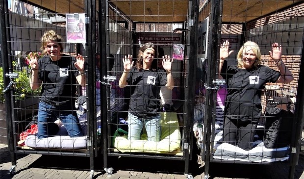 De dames die zich voor de actie 'Lock me Up – Free a Girl' lieten opsluiten in kleine hokjes (foto: Ap de Heus).