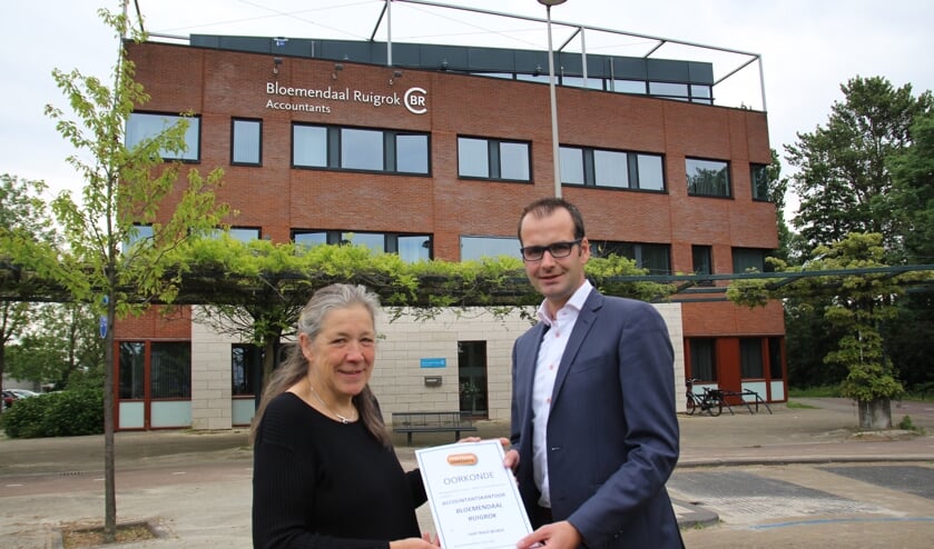 Heily van der Jagt overhandigt de Fair Trade-oorkonde aan directielid Danny Ruigrok.