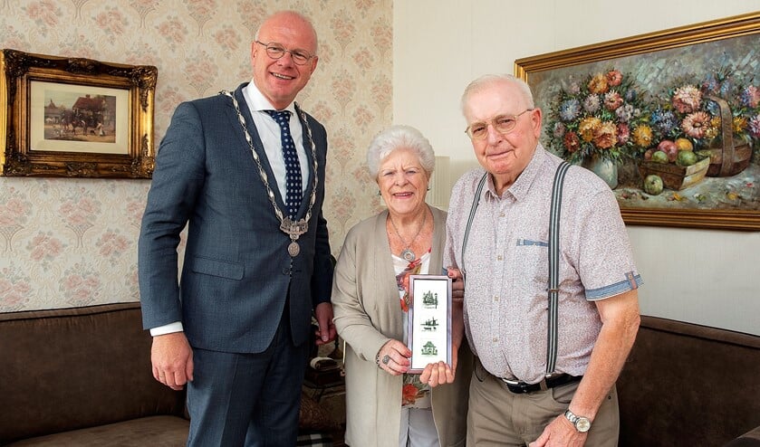 De heer en mevrouw Officier-Prins met burgemeester Klaas Tigelaar en de ets met afbeeldingen van drie lokale historische panden in Leidschendam-Voorburg (foto: Michel Groen).
