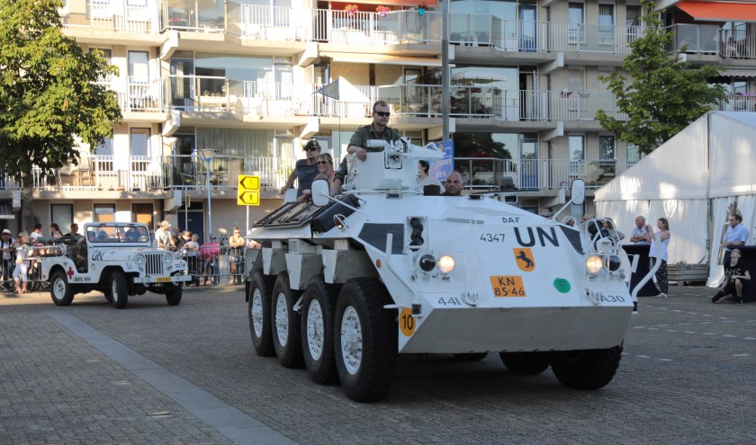Een Nederlandse pantserwagen met daarachter een jeep, beide in VN kleuren, rijden de Markt op. Foto: Jan van Es