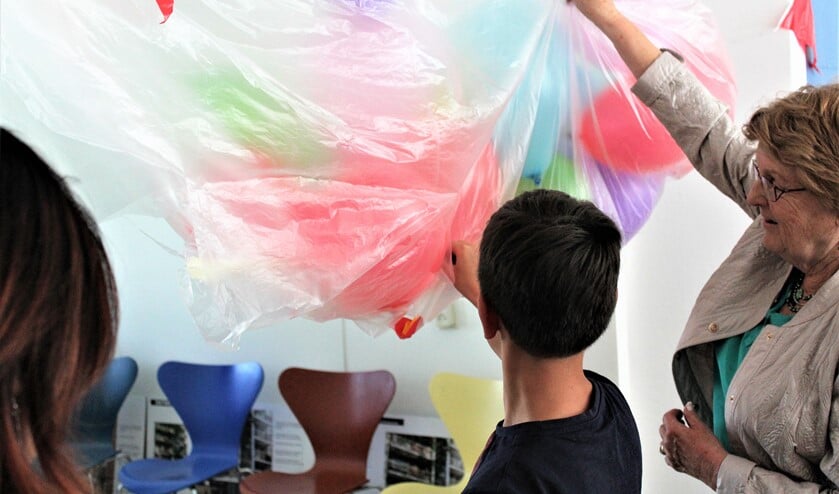 Met het doorprikken van vele ballonnen verrichtte mevrouw Eijckelhof met een jonge bewoner, de openingshandeling (foto: pr).