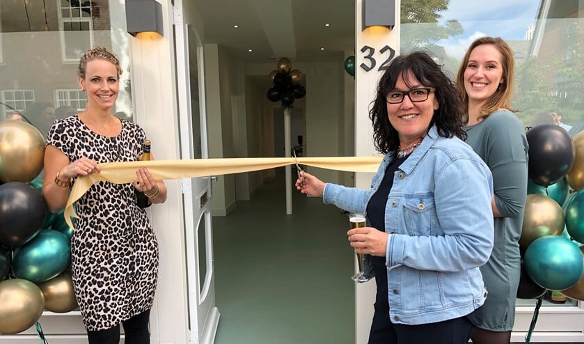 Marije Beijersbergen (links) en Nicky Heskes zijn hartstikke trots op hun nieuwe praktijk. Wethouder Van de Gevel knipt het lintje door.