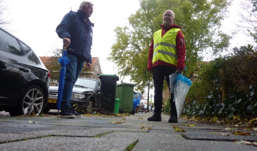 <p>Bij het meldpunt kwamen 350 meldingen binnen over ‘struikelstoepen', vertelt Bob (rechts). Links wegbeheerder Ed. Foto: Magda de Vetten</p>