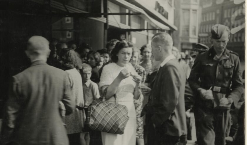 <p>IJsjes eten bij Florencia, rechts loopt een Duitse soldaat voorbij, 1943. Foto: Collectie Haags Gemeentearchief</p>