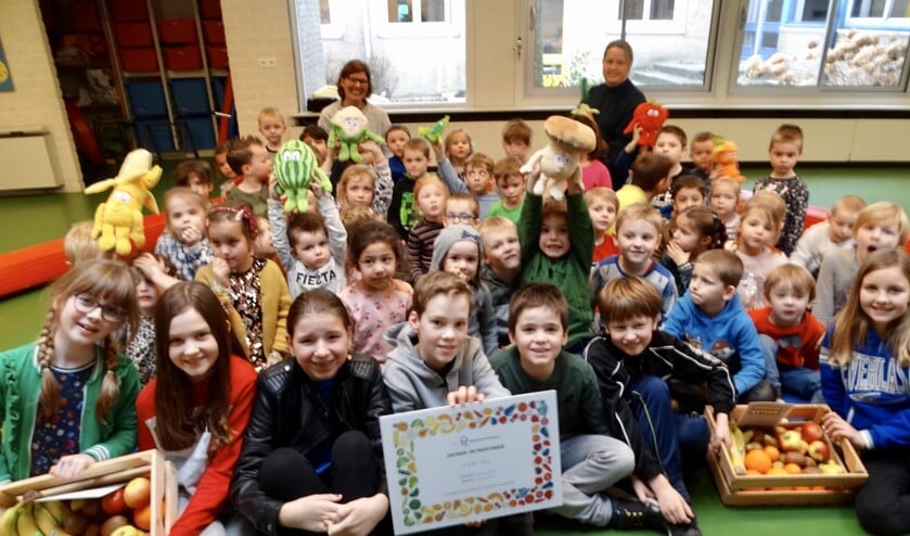 De leerlingenraad en groep 1 en 2 zijn blij met de cheque.