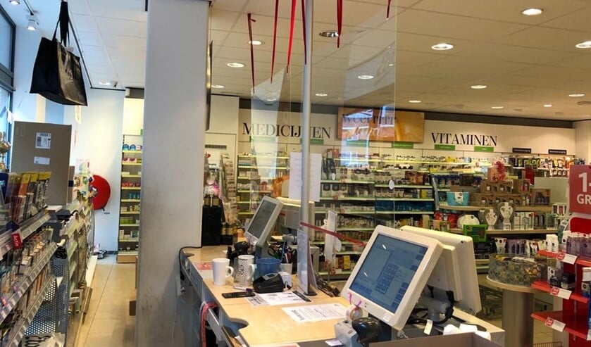 Plexiglasplaten tussen klanten en kassamedewerkers.